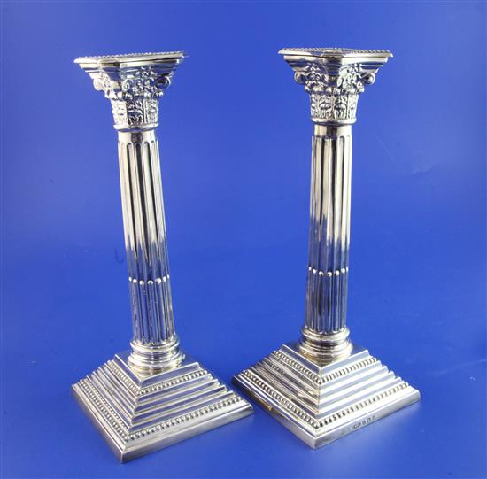 A pair of 1930s silver corinthian column candlesticks. 19 oz.